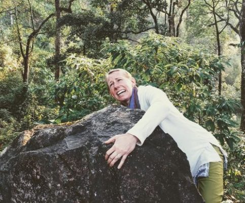 woman clinging to a rock terrified