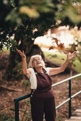 woman throwing leaves in joy, a picture of letting go