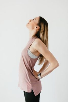 Standing camel pose variation, woman pausing to notice sensations