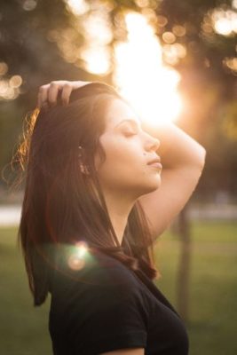 woman with eye close, pausing, breathing to accept