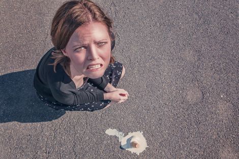 woman dropped her ice cream cone and looks upset