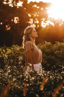 Woman in a outside standing and noticing with eyes closed