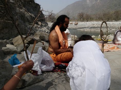 Indian Yoga teacher leading a ceremony for students on the bank of Yamuna River in India