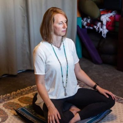 Author sitting cross-legged on a cushion with eyes closed in silence and awareness turned inwards