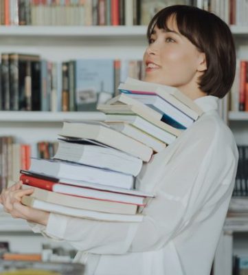 Women in a book store carrying too many books