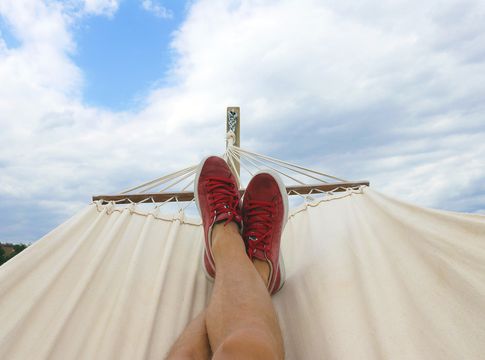 person's legs in a hammock looking at the sky