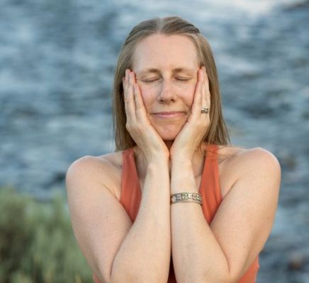 Author calm and content with eye closed and hands gently on her cheeks