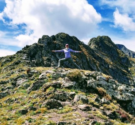 woman in Warrior 2 Pose on a mountain side