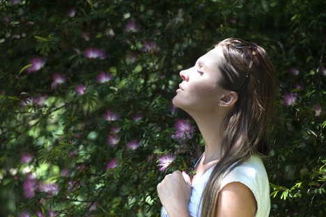 woman with eyes closed taking a breath of air