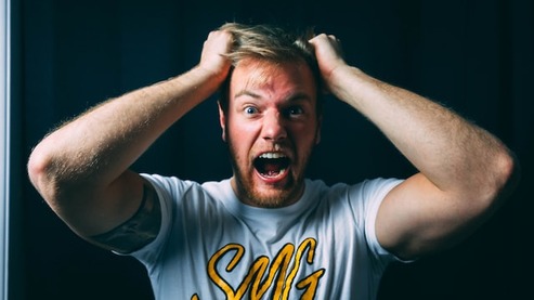 man grabbing his hair with face upset, his mind freaking out