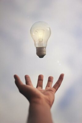 Hand catching a lighted lightbulb, I got it!