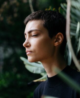 headshot of woman with her eyes closed going within to notice herself