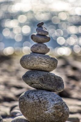 rock cairn with blurry background of beach and ocean