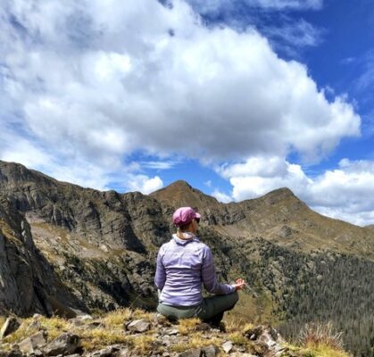 author sitting in meditation outside in the mountains overlooking a valley