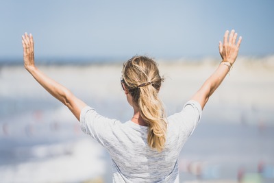 woman gazing out with arms open to receive