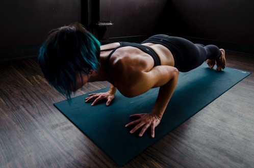 Woman in chaturanga on her blue yoga mat