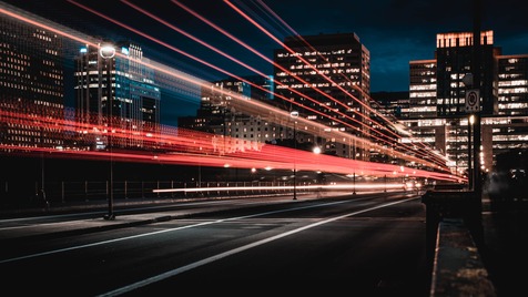 lights of a fast moving train in the night with city background 