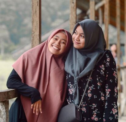 two women close together and smiling as best friends like the practice of tapas leads us to being our own best friend