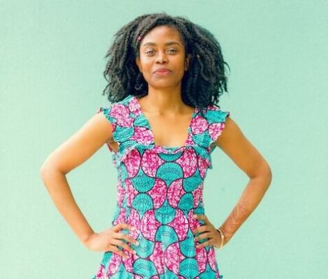 woman with hand on hips in colorful dress and green background representing the body is ready to keep us safe