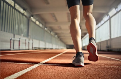 woman lower legs and feet walking on a track