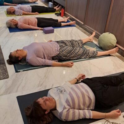 women laying in savasana letting go of effort and accepting the present moment