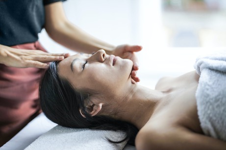 woman relaxed while receiving facial massage