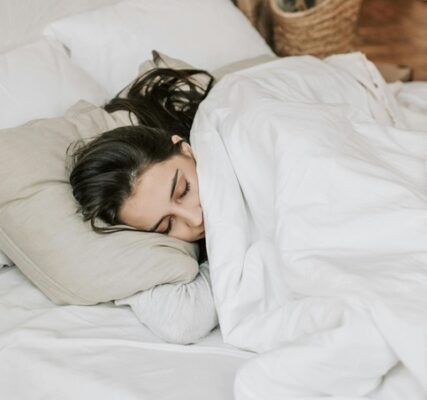 woman comfortable in bed decides not to get up quite yet ignoring her commitment to herself