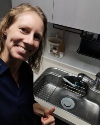 Author smiling and calm with a clean kitchen sink in the background