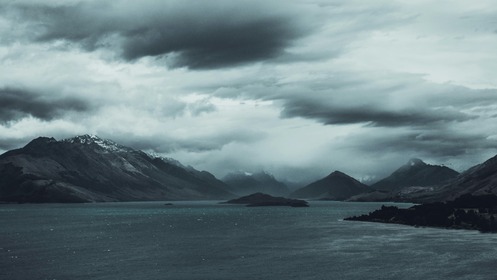 stormy skies above a mountain valley showing uncertainty