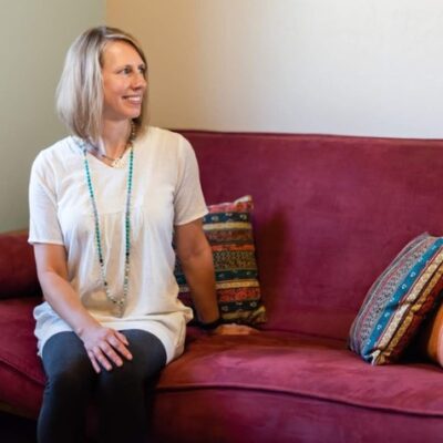 female therapist sitting on a couch looking towards where a client would sit