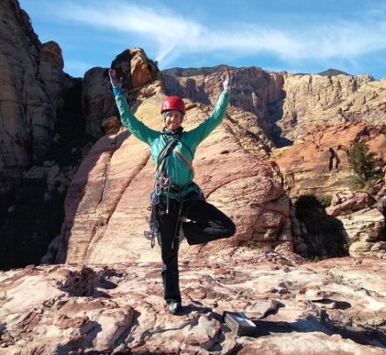 Author in tree pose at the top of a rock climb in Red Rocks State Park, Nevada