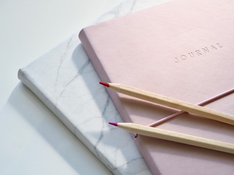 two journals and pencils to do a self-love reflection