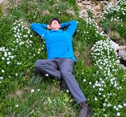 Author relaxing her body and mind laying in a field of mountain wildflowers