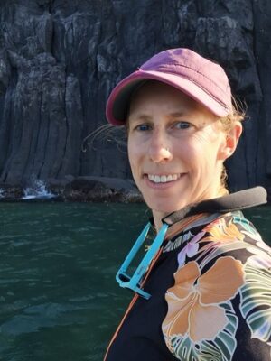 headshot of author paddleboarding by basalt cliffs