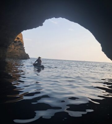 looking out from a cave on the water while paddleboarding