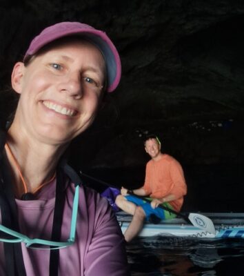 Enjoying the calm waters within a cave on paddleboards after navigating unsteady waters