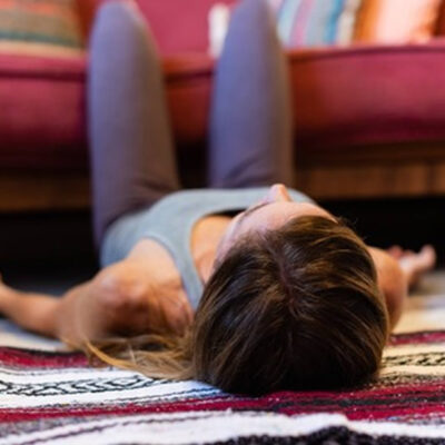 woman in a savasana variation focusing on relaxing and letting go 
