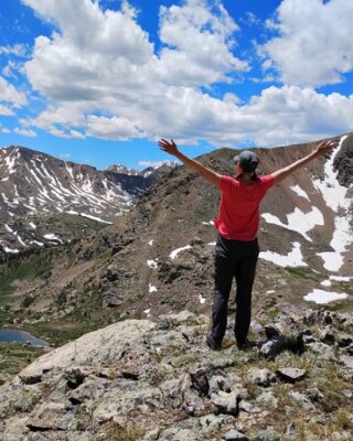 author standing on a mountaintop rejoicing in her connection to everything
